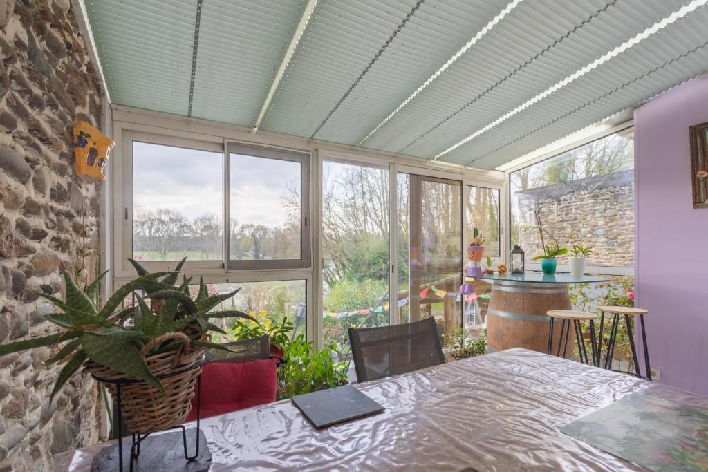 a room with a table and a large window at O’bord Du Gave in Saucède