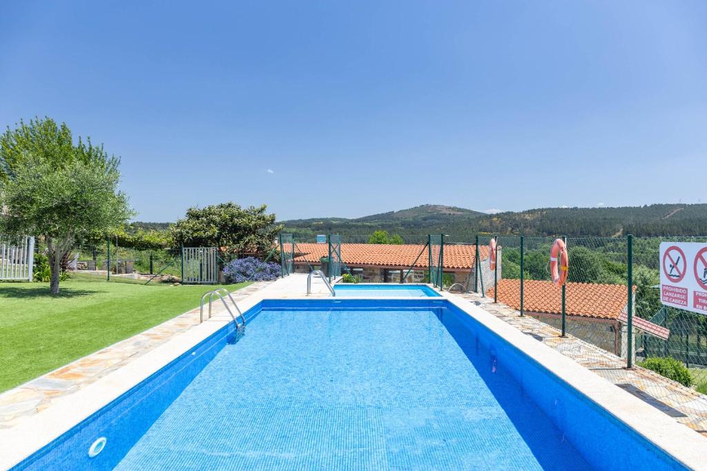 a large blue swimming pool in a yard at Casa Do Sil in Monforte de Lemos