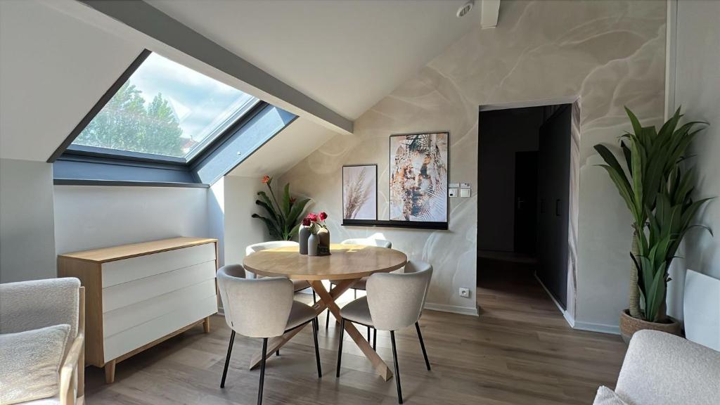 a dining room with a table and chairs and a window at Cloud Stylish flat with jacuzzi near city center in Annecy