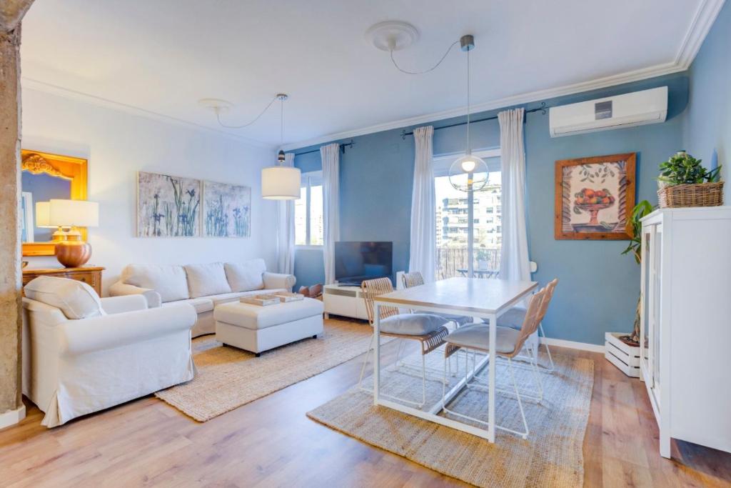 a living room with blue walls and a table and chairs at Vivir en Valencia in Valencia