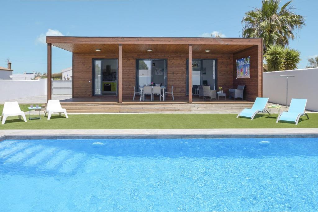 a villa with a swimming pool and a house at Casa Toria in Conil de la Frontera