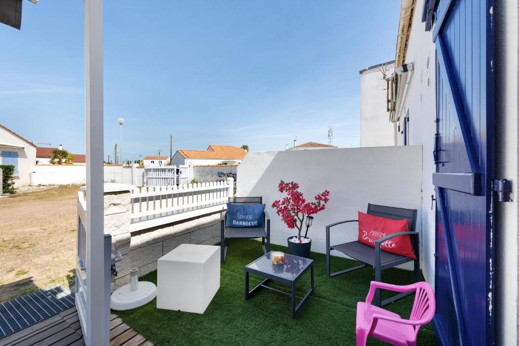 a balcony with chairs and a table on the grass at La Pause Iodée - 500 m mer in La Tranche-sur-Mer