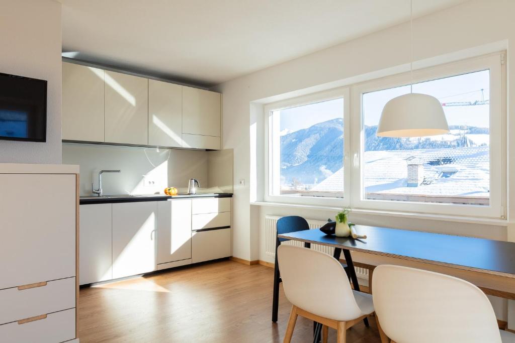 a kitchen with a table and chairs and a window at Hus Appartement - Nr. 5 in Valdaora
