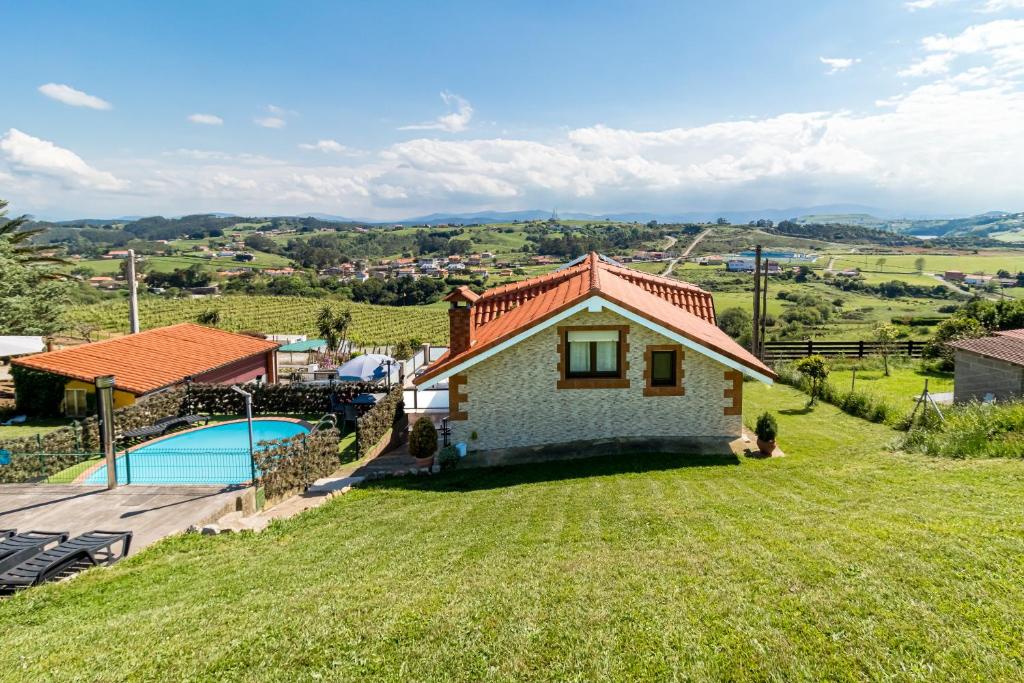 a small house on a hill with a swimming pool at La Centinela en Costa Quebrada in Miengo