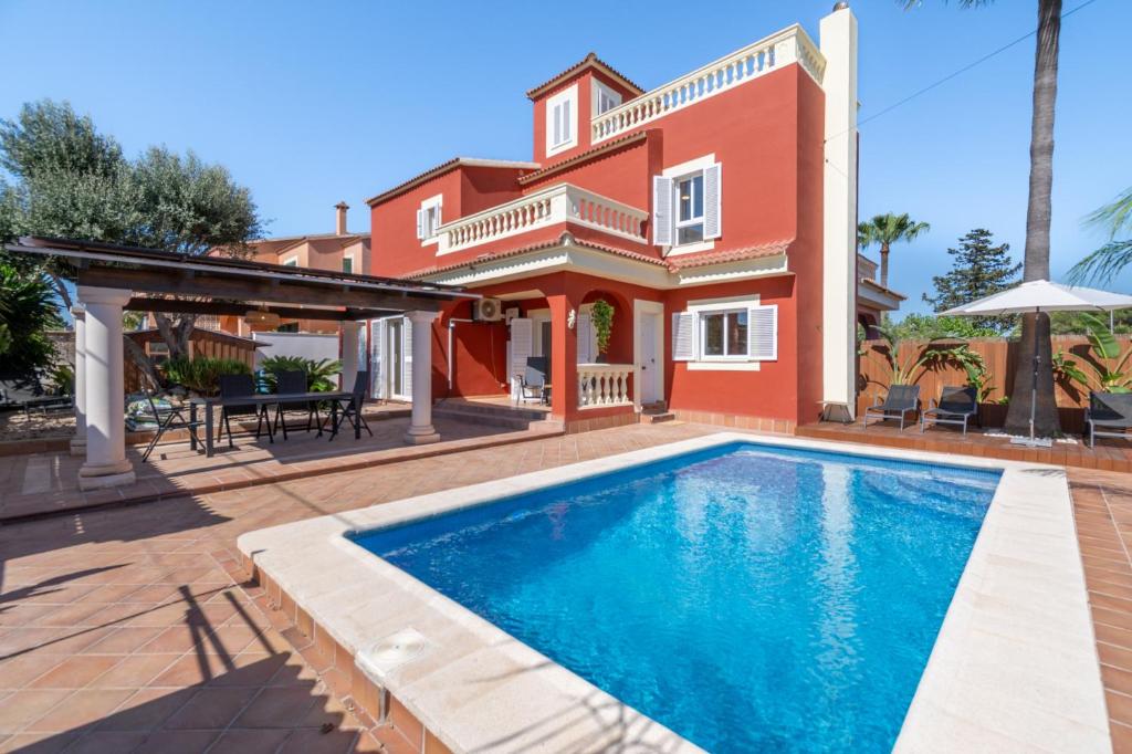 a villa with a swimming pool in front of a house at Casa de Tina in Llucmajor