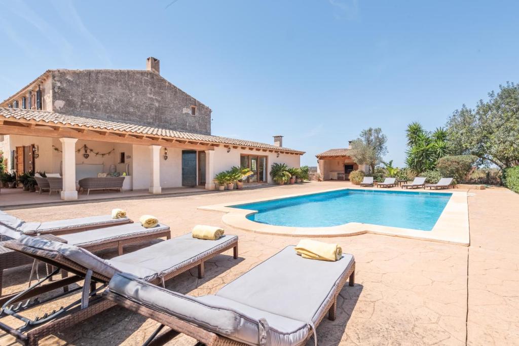 a villa with a swimming pool and a house at Can Xuri in Campos