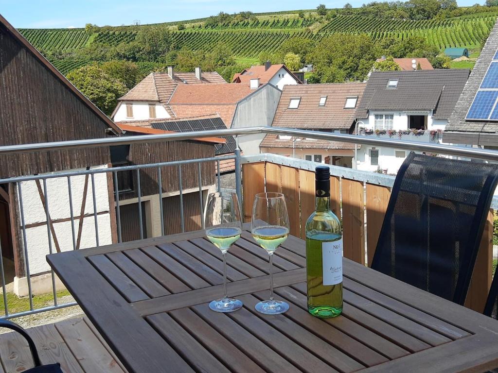 a bottle of wine and two glasses on a table at Ferienwohnung Weinbergblick in Auggen