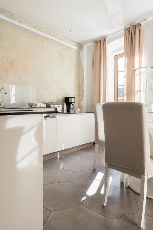 a kitchen with a table and a chair at Rennweg 114 BELAMI LIVING in Merano