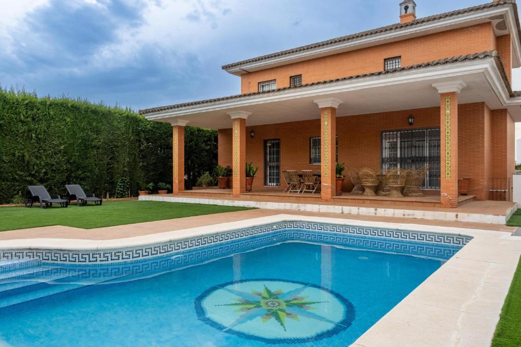 a swimming pool in front of a house at Villa Candelaria Sol y Piscina in Bormujos