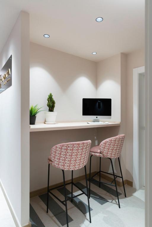 a room with two chairs and a desk with a tv at Ca Gracia Bocairent in Bocairent