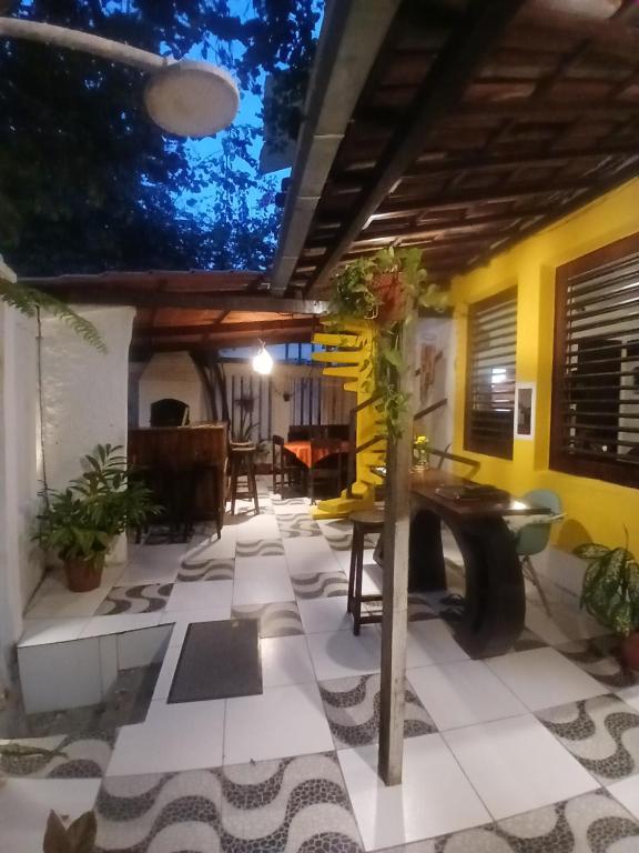 a living room with a table and a dining room at Roses hostel e pousada in Pipa