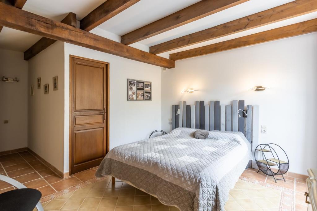 a bedroom with a bed and a wooden ceiling at Chambre Chardon, Escapade Nature in Auriac-du-Périgord