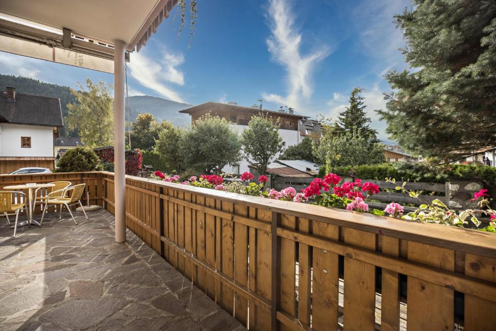 a balcony with a wooden fence and flowers at Premium App Hofer Sandra in Villabassa