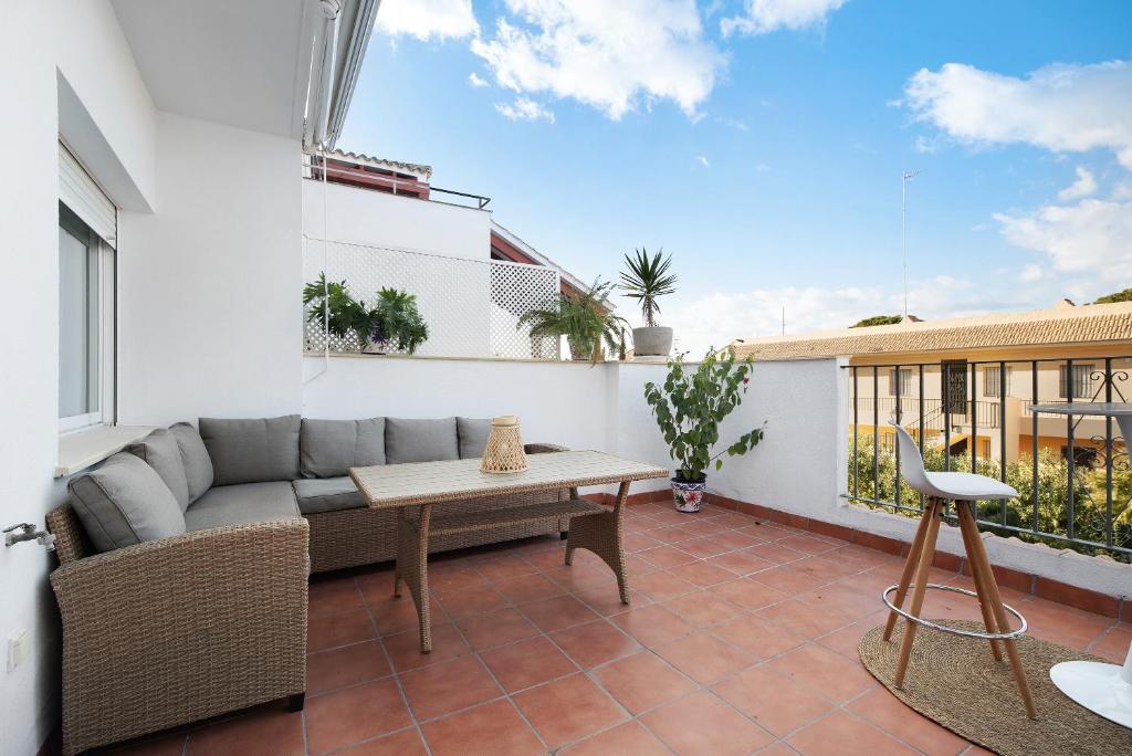 a patio with a couch and a table on a balcony at Terrazas de doñana b91a in Sanlúcar de Barrameda