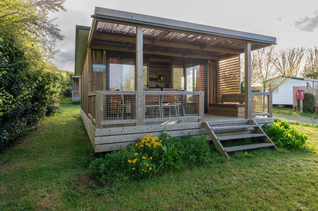 a small cabin with a porch in a yard at Chalet 35m2 - Molène in Plouhinec
