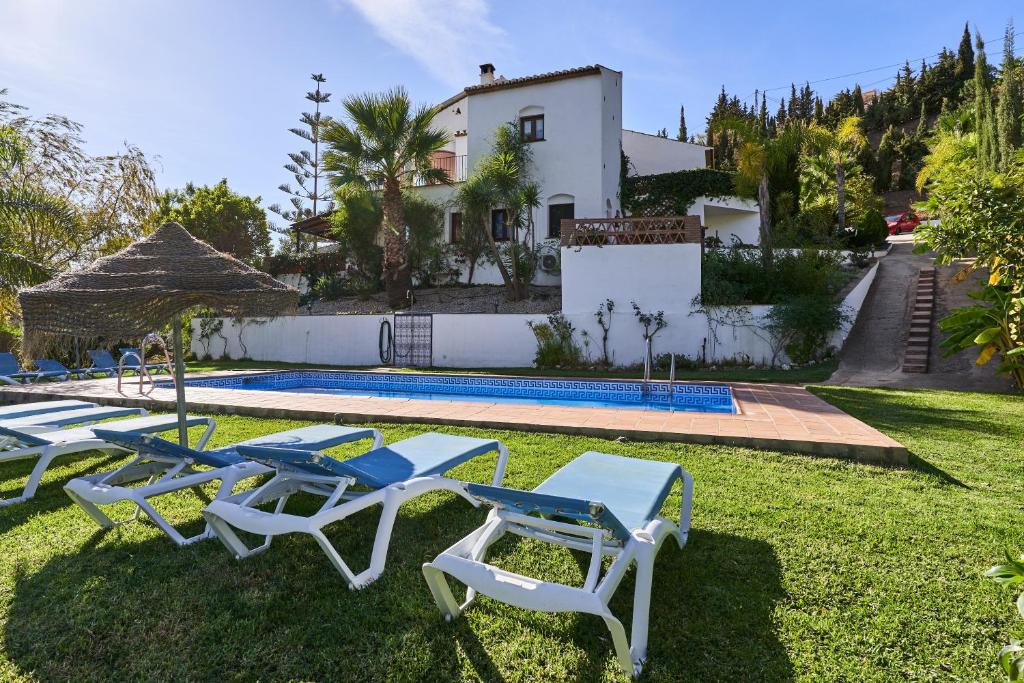 a group of lounge chairs and a swimming pool at Group Villa 14 Pool Beach 10 minute in Frigiliana