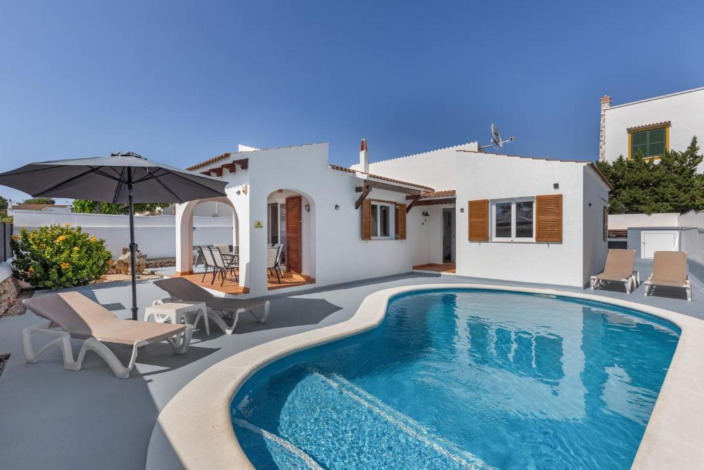 a villa with a swimming pool and a house at Villa Rose in Cala Blanca