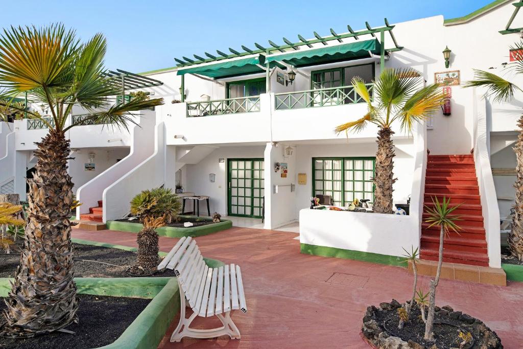 a house with palm trees in the courtyard at Los Pocillos in Los Pocillos