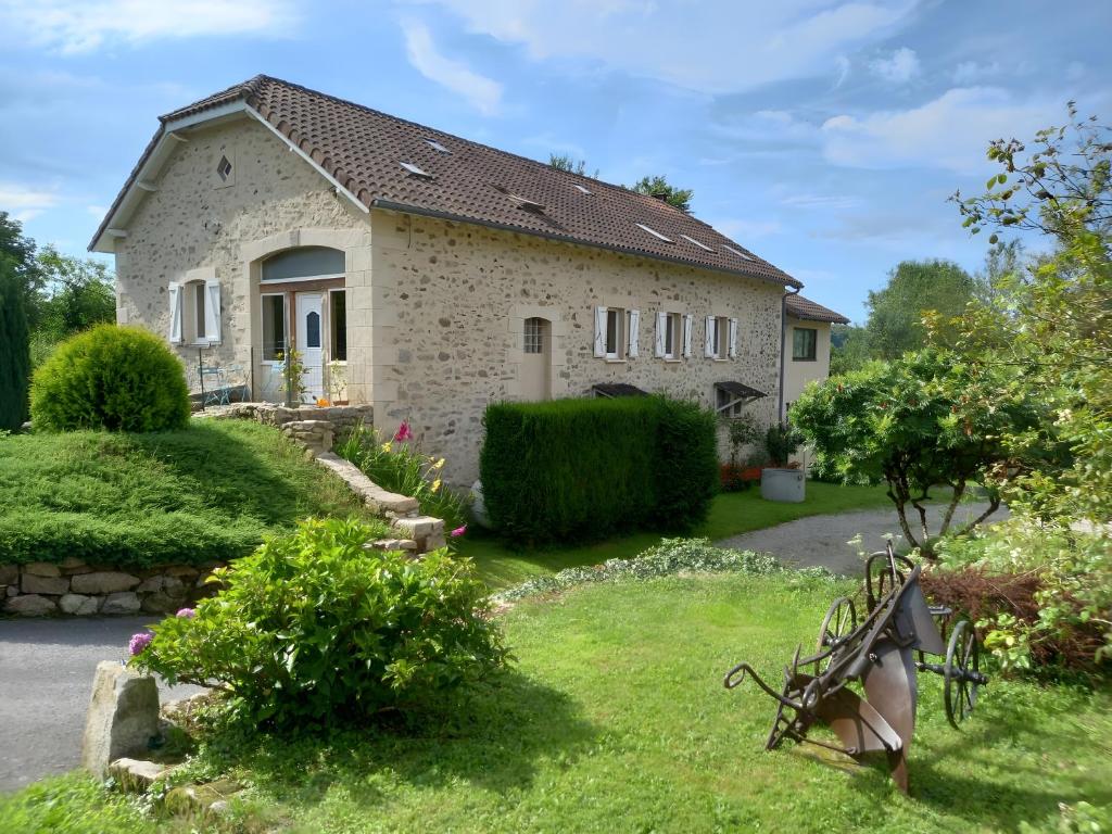 a stone house with a garden in front of it at Les Vallons du Lot in Gorses