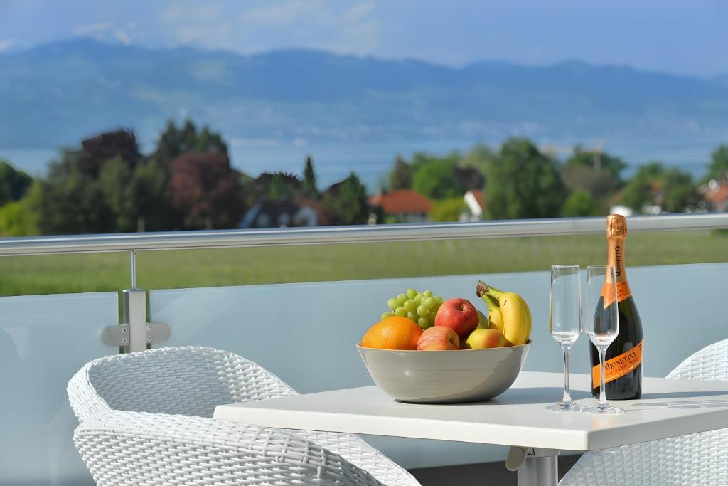 a table with a bowl of fruit and a bottle of wine at Dinkelbach Traumblick 3 C in Hengnau