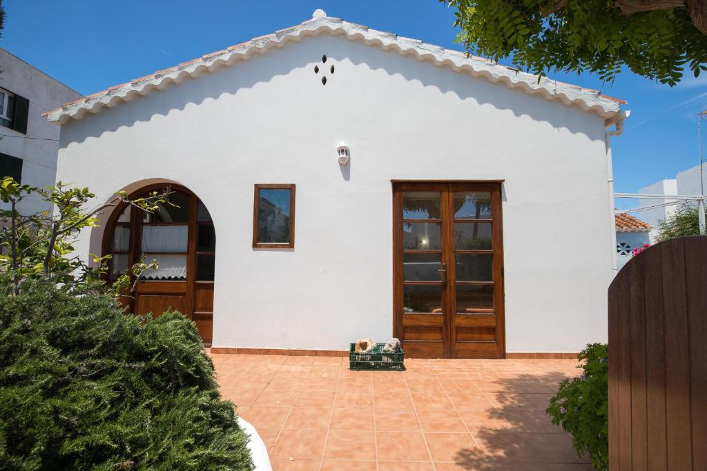 a small white house with a large door at Villa Republica Argentina in Ciutadella