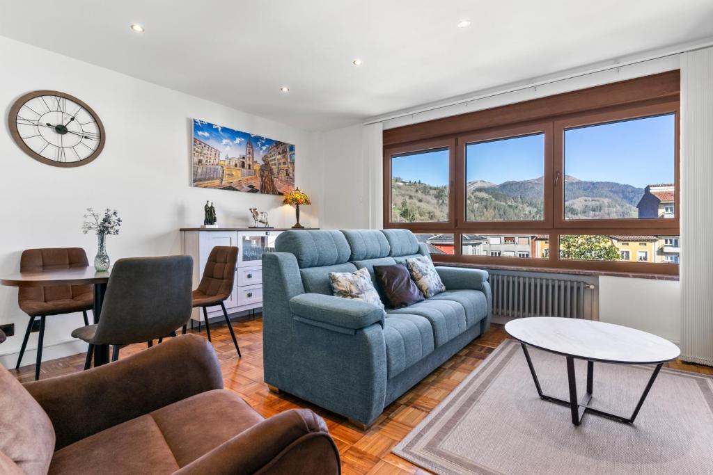 a living room with a blue couch and a table at Comarca del Sella in Arriondas