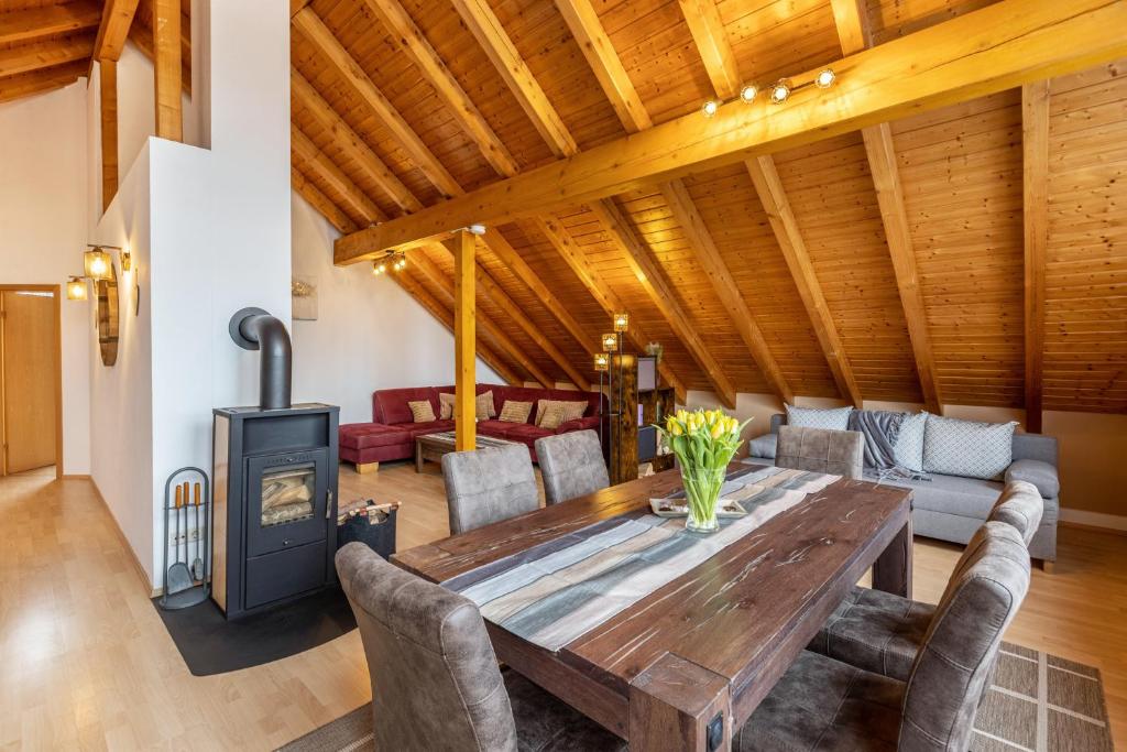 a living room with a wooden table and a wood stove at Ferienwohnung Auf dem Hohen in Hüfingen