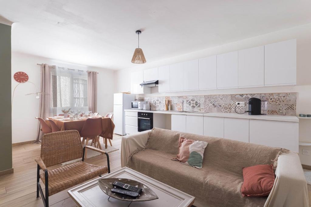 a living room with a couch and a kitchen with a table at Bel appartement 3 piece in Saint-Hippolyte