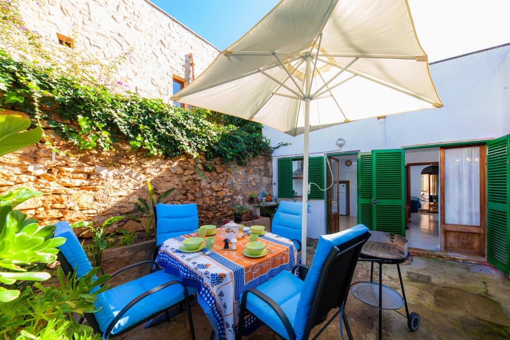 a table and chairs with an umbrella on a patio at Villa Ca Sa Padrina in Santanyi