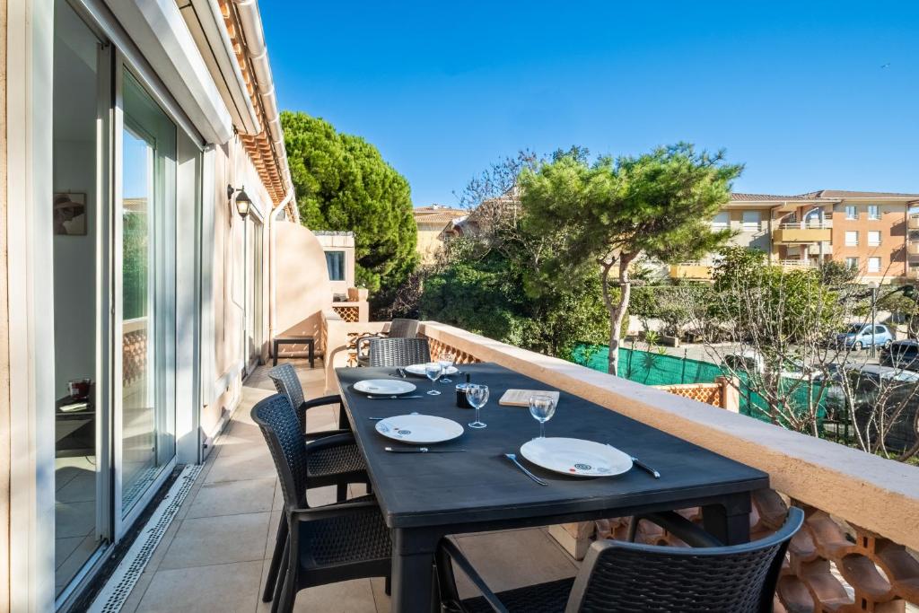 a table on the balcony of a house at Courtille sur Mer - port de Frejus in Fréjus