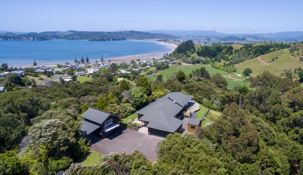 an aerial view of a house with a beach at Treetops Cottage at the Castle in Whitianga