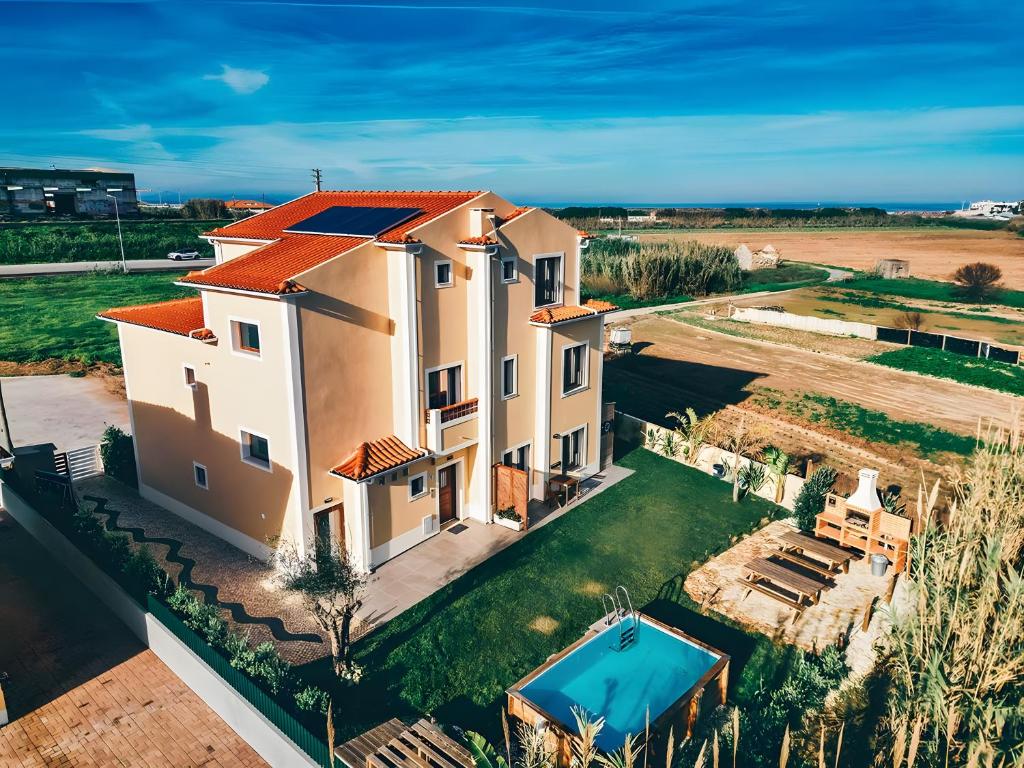 an aerial view of a house with a swimming pool at Drop In Beach Apartments in Lourinhã