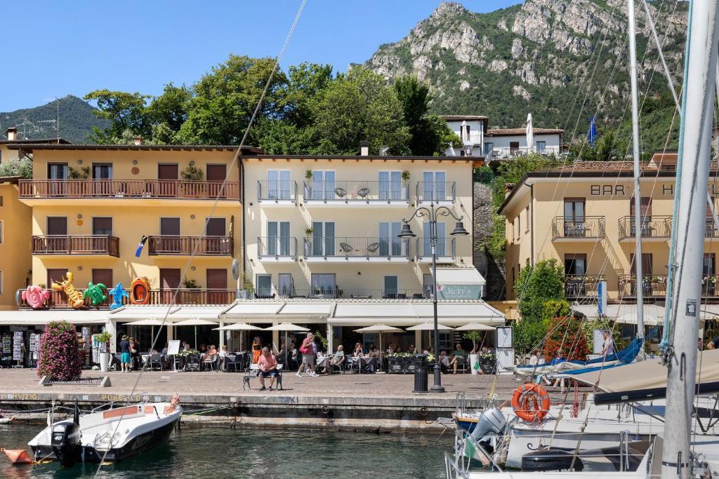 a group of buildings and a marina with boats in the water at Jacky's Apartments in Limone sul Garda