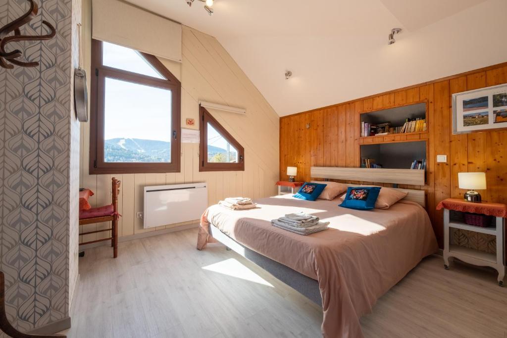 a bedroom with a large bed and a window at Le Chalet des Beuquillons in Gérardmer