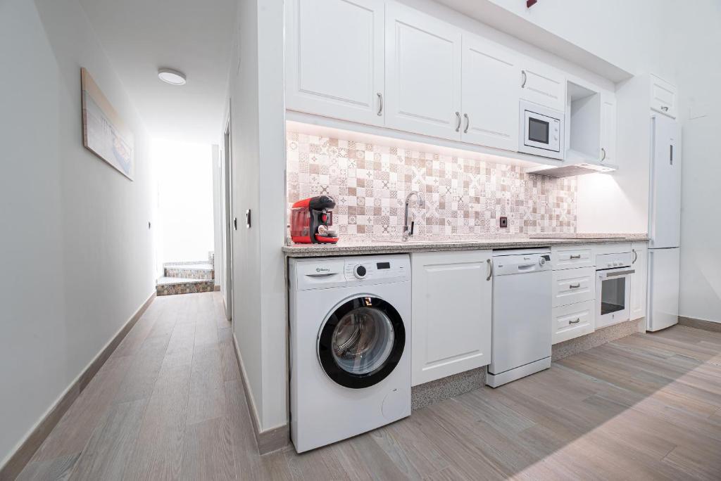 a white kitchen with a washing machine in it at Ocean Suites A3 in Isla Cristina