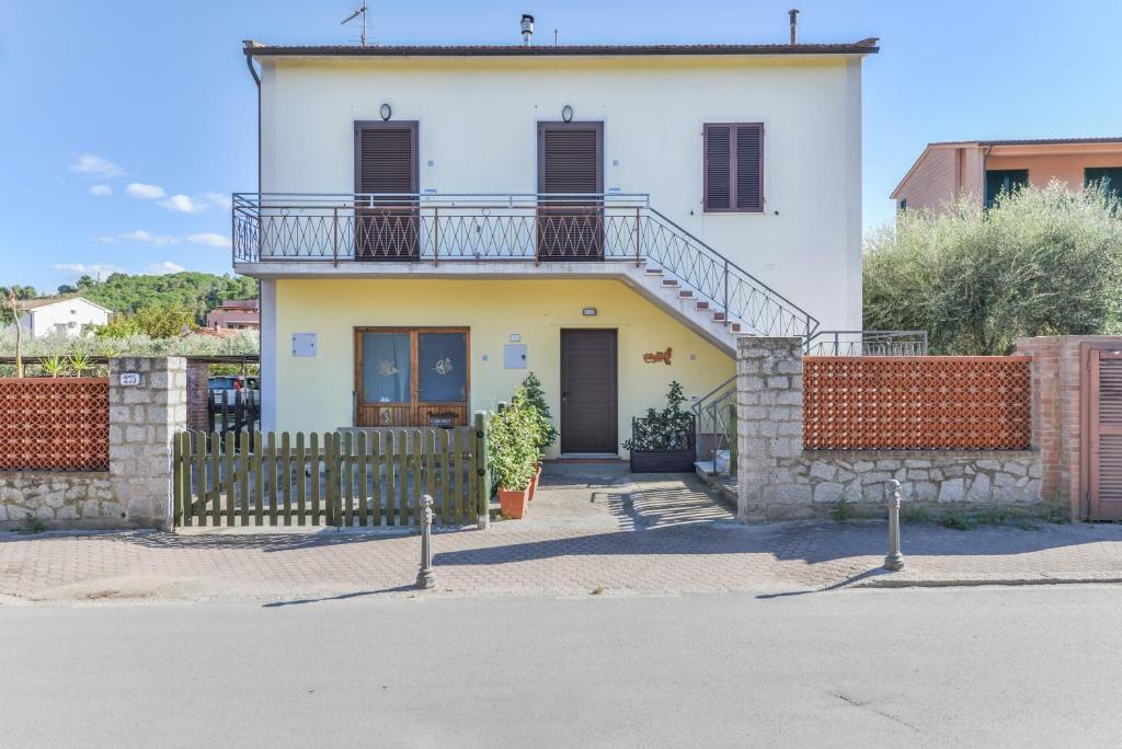 a white house with a balcony on top of it at Appartamenti Marisol in Campo nell'Elba