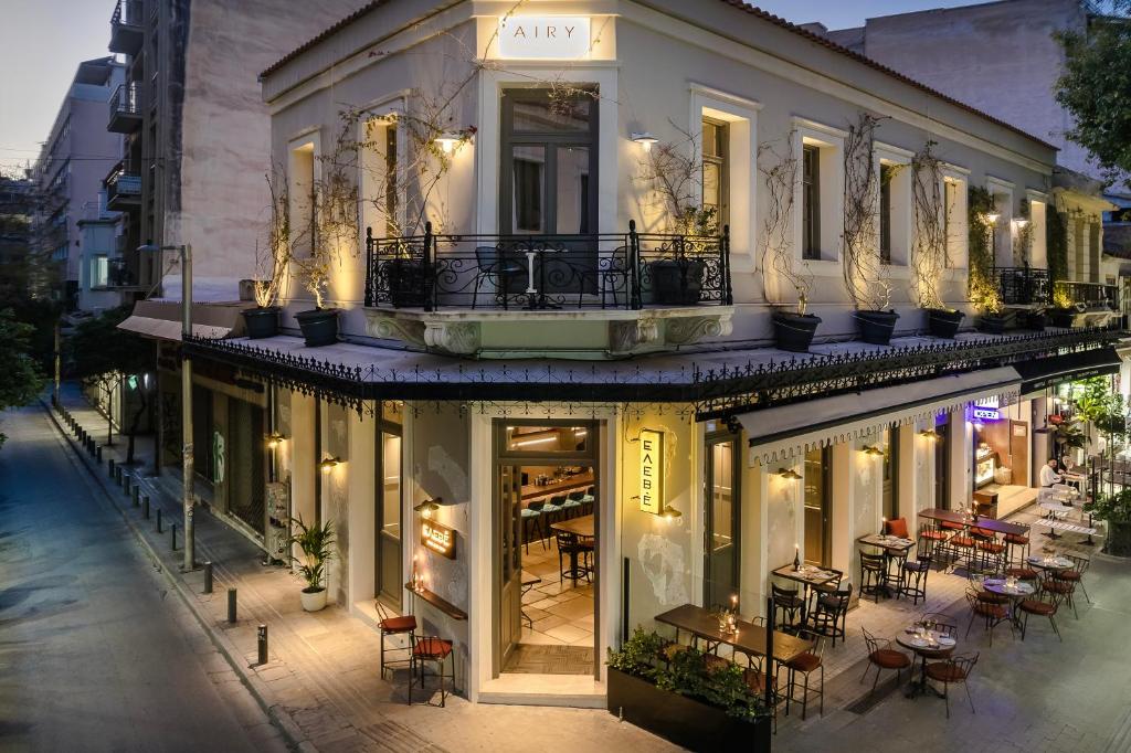 a building with tables and chairs on a street at Airy Athens Suites in Athens