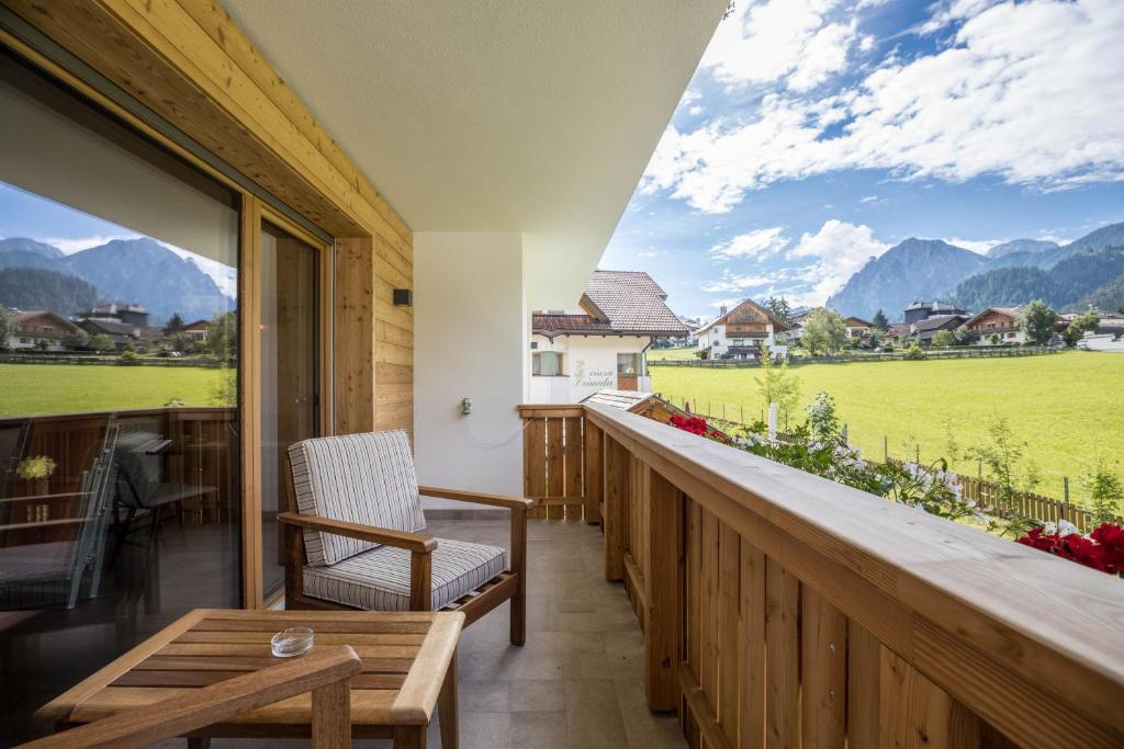 a balcony with a view of a field and mountains at App. Col Toronn - Ciasa Lavarella in San Vigilio Di Marebbe