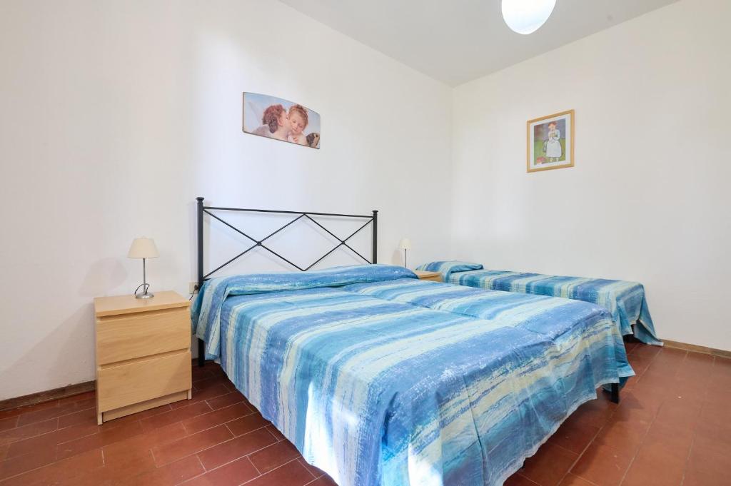 a bedroom with two beds and a night stand at Mare Etrusco 5 in Populonia