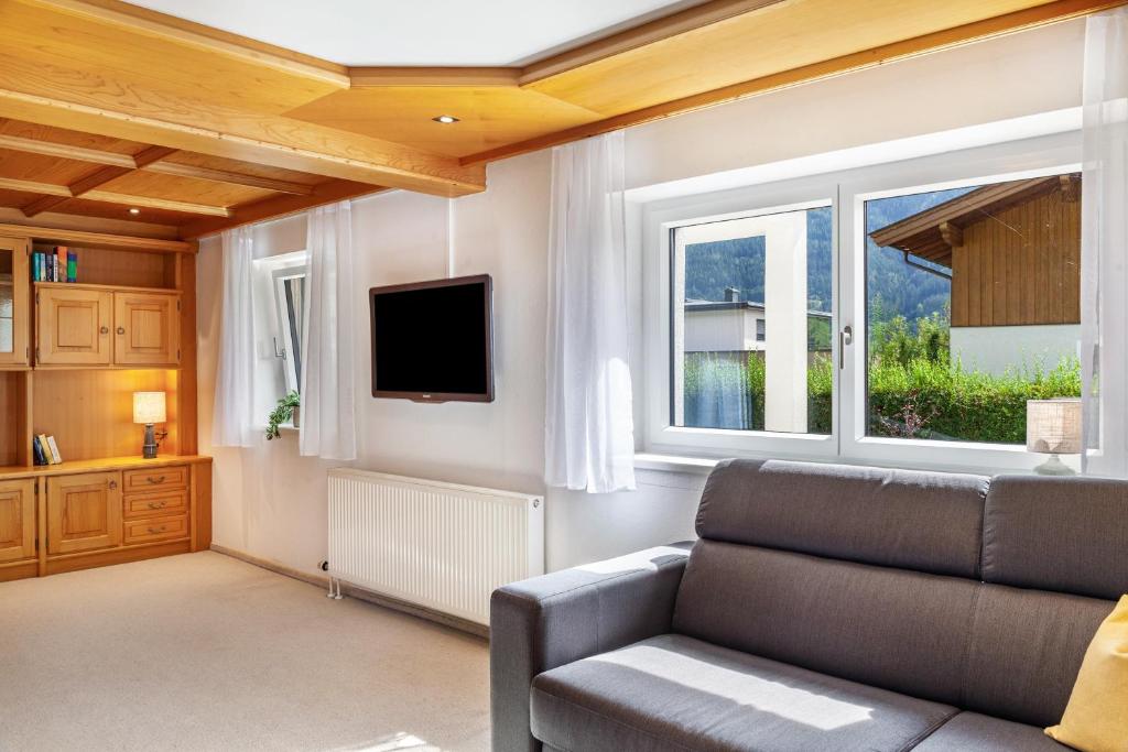 a living room with a couch and a tv at Ferienwohnung Pfeffer in Leogang