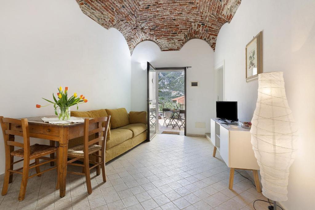 a living room with a table and a couch at Ciliegio Agriturismo La Ferla in Toirano