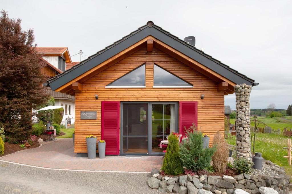 a small house with a red door at Schorenmoos Lodge in Dietmannsried