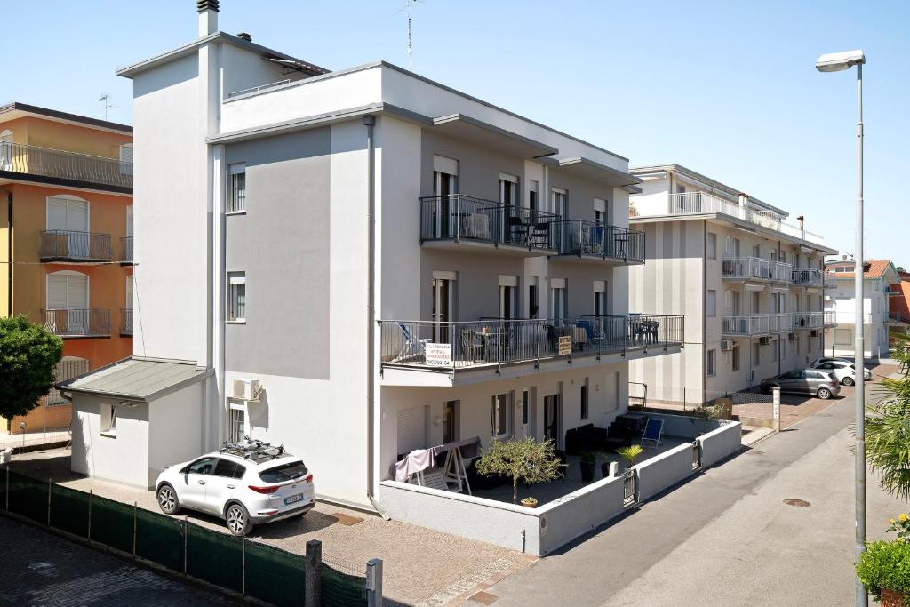 a white building with a car parked in front of it at Villa Trentina in Lido di Jesolo