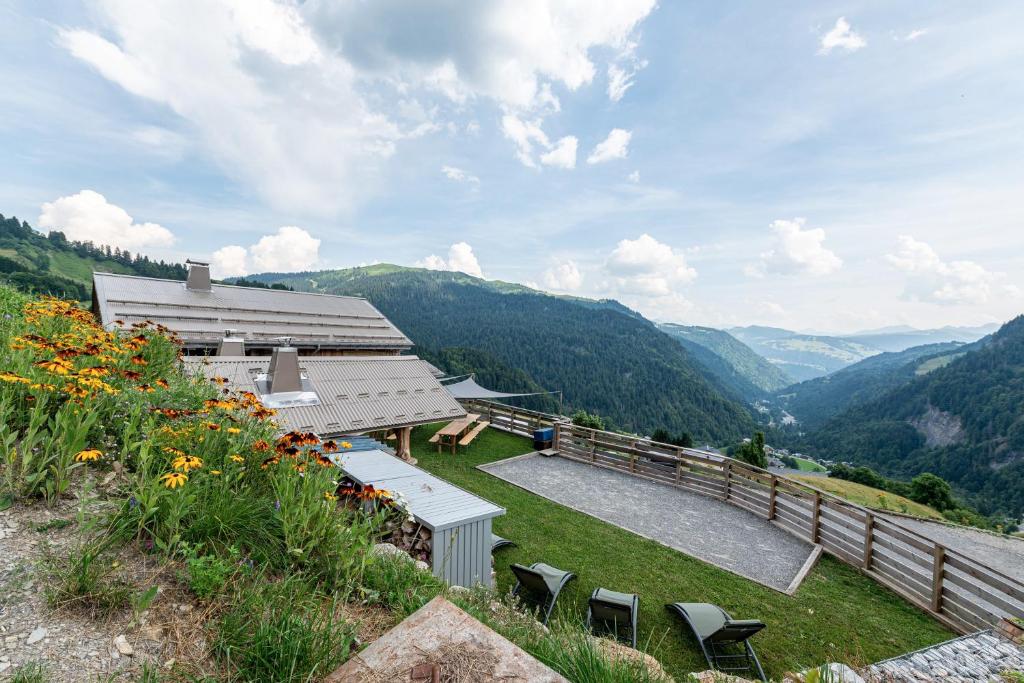 a building on a hill with a view of mountains at Gite Les Clapières in La Giettaz