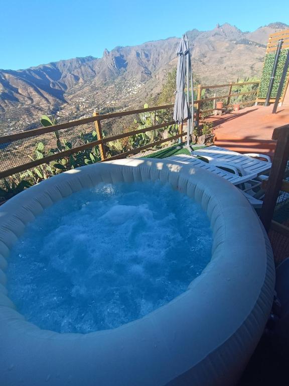 a large hot tub with a view of the mountains at Ca' Navarro in Vega de San Mateo