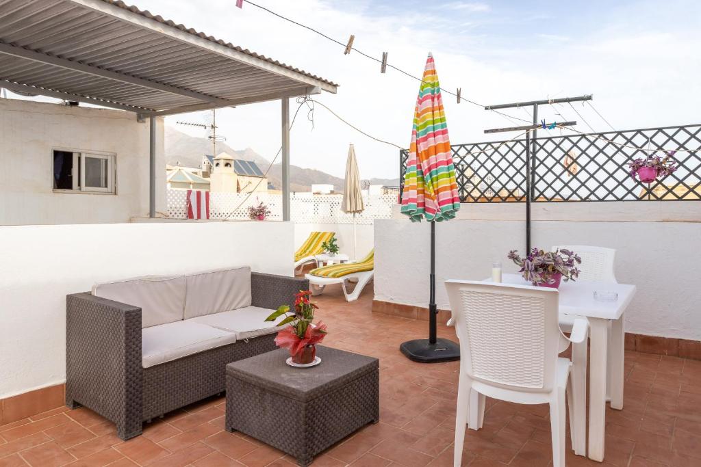a patio with a table and chairs and an umbrella at Apartment Nieves 2 in Nerja