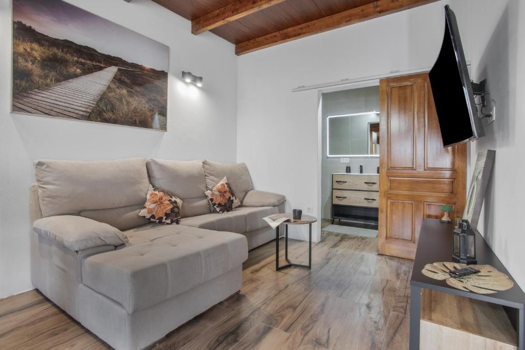 a living room with a couch and a flat screen tv at El Refugio De Los sueños in Uga
