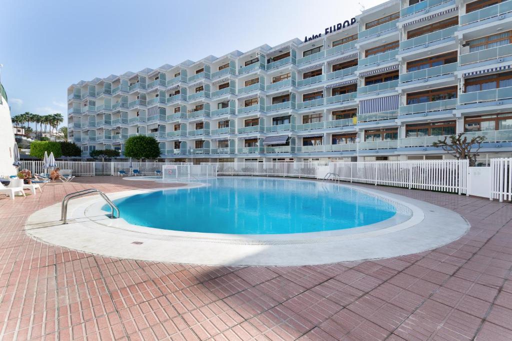 a swimming pool in front of a large building at Estudio Yumbo Playa Del Ingles in San Bartolomé