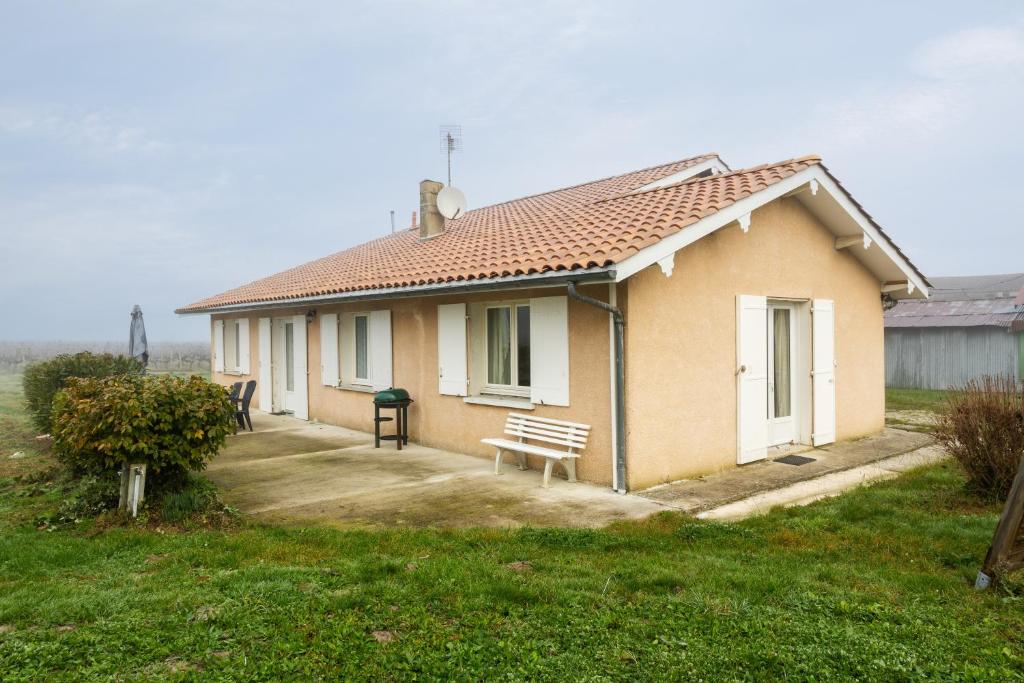 a small house with a bench in front of it at Gite du maine in Langon
