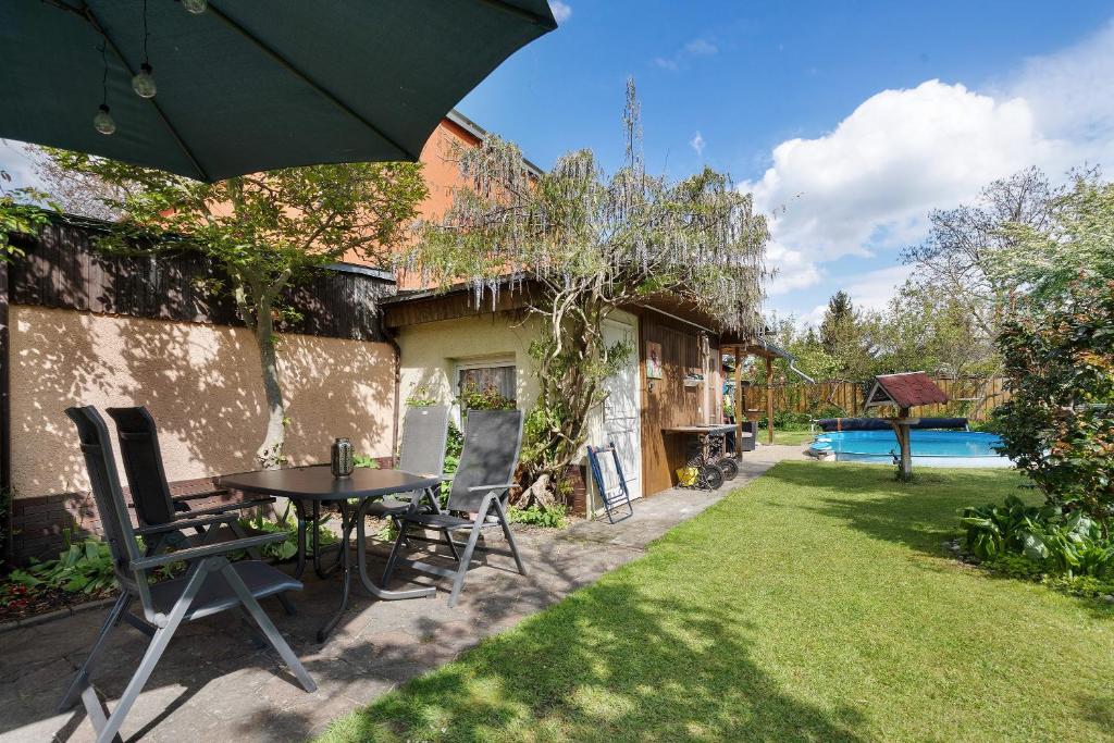 a patio with a table and chairs and an umbrella at Ferienwohnung mit Aufenthaltsraum in Ruhland